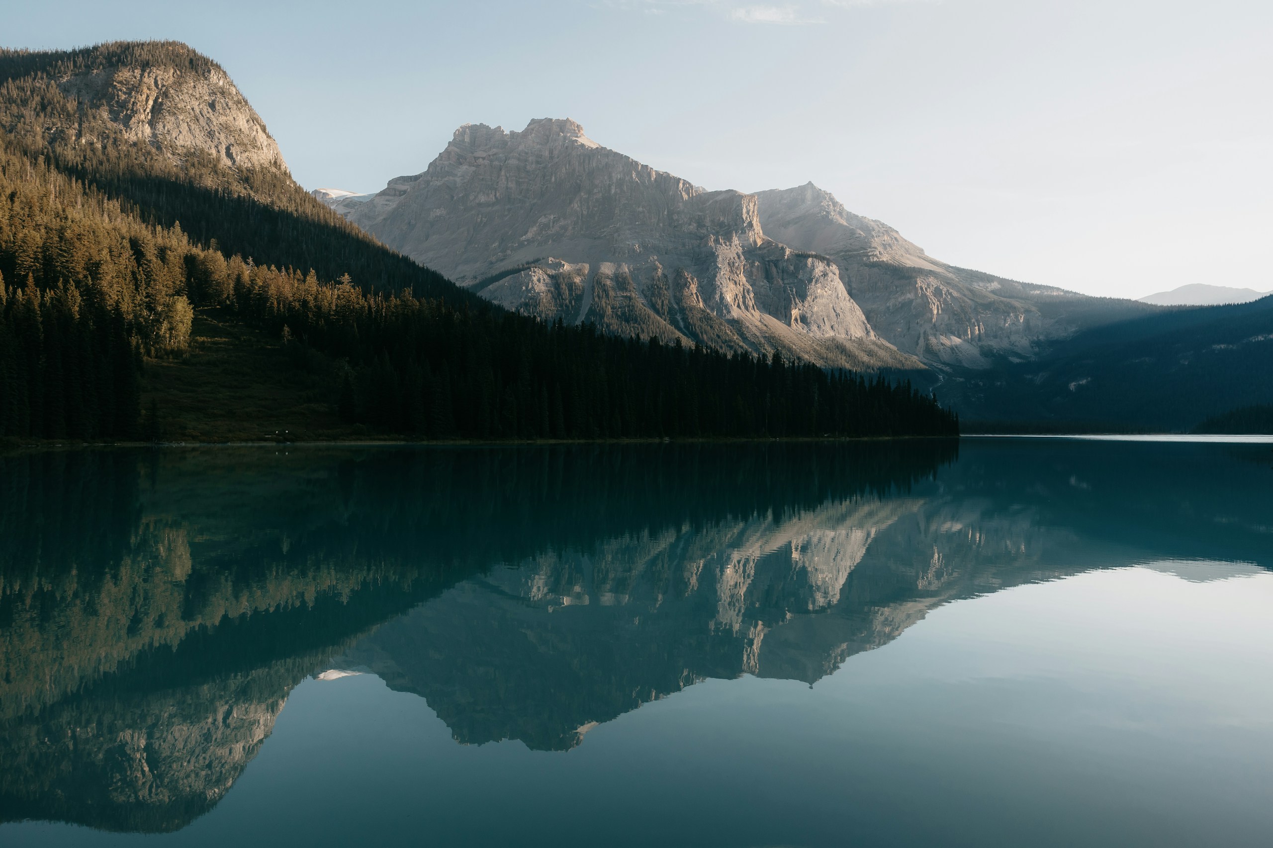 Morning light over mountains, forest and a still lake in Banff, Canada